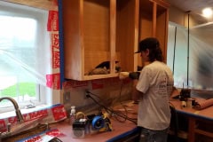 Sanding kitchen cabinet carcass during cabinet refinishing preparation in Groton MA