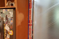 Cabinet side panel partially sanded during cabinet refinishing preparation in Groton MA