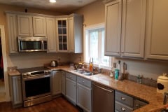 Kitchen cabinet painting project in Groton MA by Finish Masters Builders Corp showing professionally refinished cabinets with a smooth sprayed finish
