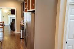 Refrigerator pantry cabinet freshly refinished without doors installed during cabinet painting project in Groton MA
