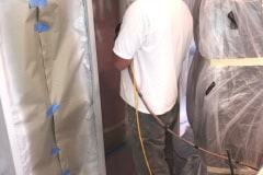 Spraying kitchen cabinet frames with professional coating during cabinet refinishing project in Groton MA