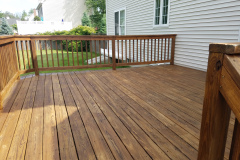 mahogany farmers porch floor restoration project in Littleton Massachusetts with white columns and sealed hardwood deck