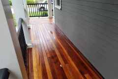 Beautifully restored hardwood porch with polished finish, enhancing curb appeal and durability.