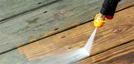 Power washing and painting wooden deck for restoration and protection.