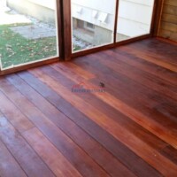 Expert hardwood floor refinishing by Finish Masters Construction & Painting, enhancing the natural beauty of the wood. Beautifully refinished hardwood floor in a sunlit room with large windows.