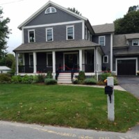 Expert house painting and construction services by Finish Masters Construction & Painting. Beautiful gray house with fresh exterior paint and well-maintained landscaping.
