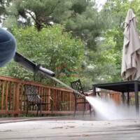 A worker power washing an outdoor deck to restore its appearance and cleanliness. Professional exterior power washing service by Finish Masters Construction & Painting.