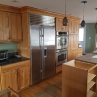 Beautifully renovated kitchen featuring custom wood cabinets and stainless steel appliances. Kitchen remodeling with custom wood cabinets and modern appliances.