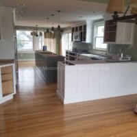 A spacious kitchen with updated cabinetry, hardwood floors, and ample natural light. Kitchen renovation featuring new white cabinets and hardwood flooring.