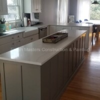 Spacious kitchen featuring white cabinetry, a central island, and large windows for bright, open living space. Kitchen with white cabinets, island, and natural light.