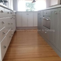 Modern kitchen with custom cabinetry and hardwood floors, showcasing professional construction and painting expertise. Kitchen renovation with custom cabinets and hardwood flooring. Expert construction and painting serv.