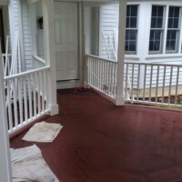 Professional painting of residential porch with durable red finish. Exterior porch with freshly painted red wood flooring.