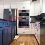 Beautifully renovated kitchen featuring white cabinetry and stainless steel appliances by Finish Masters. Modern kitchen renovation with white cabinets and stainless steel appliances.
