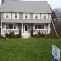 Finish Masters painting team applying fresh paint to a spacious, well-maintained home exterior, enhancing curb appeal and protection. Professional house painting service by Finish Masters on a large two-story home.