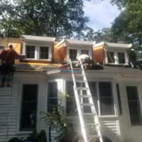 Roof and exterior painting in progress on a residential home.