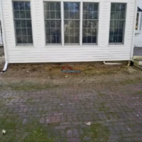 Exterior house foundation repair and painting.