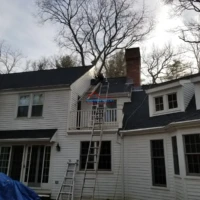 House with chimney undergoing repair and painting by Finish Masters Construction & Painting.