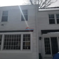 Exterior view of a white house with recent painting and construction work by Finish Masters.