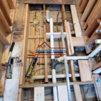 Interior plumbing setup with pipes and fittings during renovation process. Plumbing installation in a construction site for renovation project.