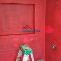 Professional interior wall painting by Finish Masters, showcasing a vibrant red color. Interior wall painting with a ladder and painting supplies visible.