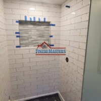 Bathroom wall tiling process completed by Finish Masters Construction & Painting, showcasing quality craftsmanship. Professional wall tile installation in a bathroom by Finish Masters Construction & Painting.