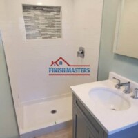 Expert bathroom remodeling by Finish Masters Construction & Painting. Bathroom shower with tile accent wall and new vanity.