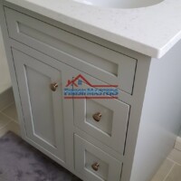 Quality bathroom renovation by Finish Masters Construction & Painting, showcasing a sleek vanity with modern fixtures. Bathroom vanity with white countertop and modern fixtures.