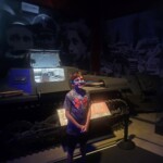 Child standing in front of a military tank display at a museum. Military tank exhibit at museum.