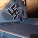 Close-up of a WWII aircraft tail featuring a swastika symbol. Aircraft tail with swastika symbol, historical WWII aircraft restoration.