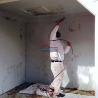 Skilled painter working on ceiling painting project in a home interior. Professional painter applying ceiling paint in a residential room.