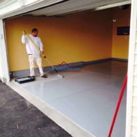 Professional garage floor coating being applied for a durable, smooth finish by Finish Masters. Garage floor coating application by Finish Masters Construction & Painting.