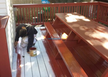 Finish Masters applying stain to a wooden deck for weather protection and aesthetic enhancement. Professional deck staining and sealing service for a durable, attractive outdoor space.