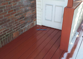 Professional deck staining and sealing service on a residential porch. Deck staining and sealing by Finish Masters.