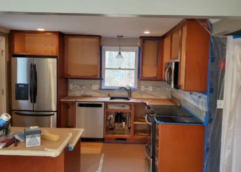 Preparation is the foundation of a flawless finish. Cabinet doors have been removed, surfaces protected, and masking completed as we begin the cabinet refinishing process in Tewksbury, Massachusetts. Kitchen cabinet painting preparation in Tewksbury MA with doors removed floor protection installed and masking completed before sanding and refinishing begins.