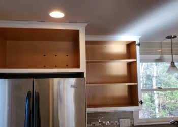 The upper cabinet boxes above the refrigerator have been fully refinished and are ready for reassembly. It's the culmination of a process built on preparation, craftsmanship, and accountability—not shortcuts. Finish Masters cabinet refinishing project in Tewksbury Massachusetts showing completed upper cabinets above the refrigerator ready for door installation and final reassembly.