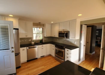From every angle, the difference is clear. Professional preparation, premium coatings, and uncompromising craftsmanship combine to create a finish that Finish Masters is proud to stand behind with our name, reputation, and written warranty. Finish Masters cabinet refinishing project in Tewksbury Massachusetts showing an angled view of the completed kitchen featuring professionally refinished cabinets and a better-than-factory finish.