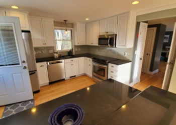 A finish is only as good as the craftsmanship behind it. From every angle, this Tewksbury kitchen reflects the preparation, attention to detail, and accountability that define the Finish Masters name. Finish Masters cabinet refinishing project in Tewksbury Massachusetts showing an angled view of the completed kitchen with professionally refinished cabinets and our reputation-backed better-than-factory finish.