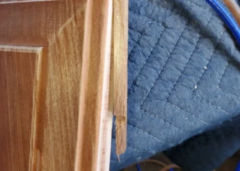 Cabinet drawer front repair in progress. Proper repairs ensure a flawless, factory-quality finish once refinishing is complete. Damaged cabinet drawer front repair before refinishing by Finish Masters Builders Corp