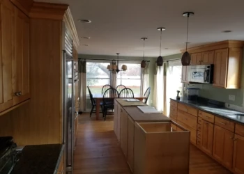 Kitchen cabinets being refinished in a home interior.