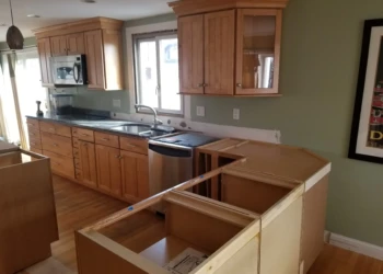 Kitchen cabinet refinishing process with unfinished cabinets and new hardware.