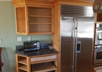 Kitchen cabinet refinishing with new wood finish and open shelves.