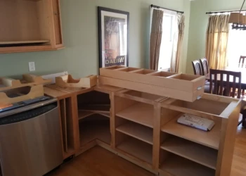 Unfinished wooden cabinets being refinished in a kitchen.