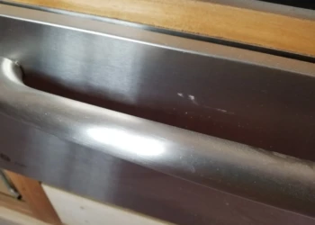 Close-up of a cabinet drawer being refinished with a smooth, shiny surface.
