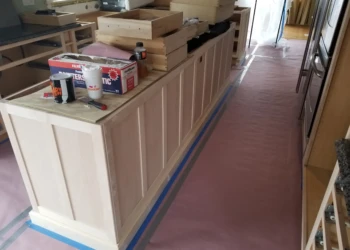 Kitchen cabinets being refinished with paint and primer.