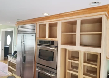 Unfinished wooden cabinets being refinished in a kitchen.