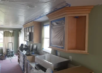 Kitchen cabinets being refinished with new paint and finish.