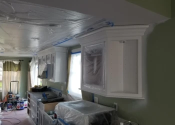Kitchen cabinets being refinished and painted in a home renovation project.