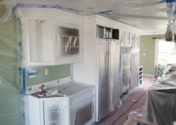 Kitchen cabinets being refinished and painted in a home renovation project.