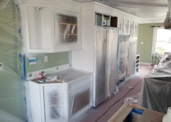 Kitchen cabinets being refinished and painted in a home renovation project.