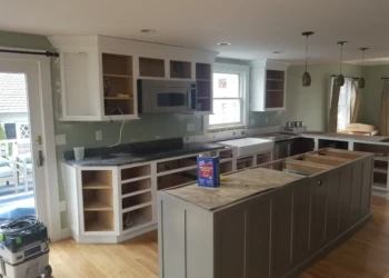 Kitchen cabinets being refinished and painted in a modern home.